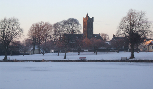 Castle Douglas from Carlingwark Loch. Our office is just behind the old church.